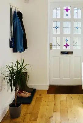 a hallway with a door and a potted plant at Little Peterville in St. Agnes
