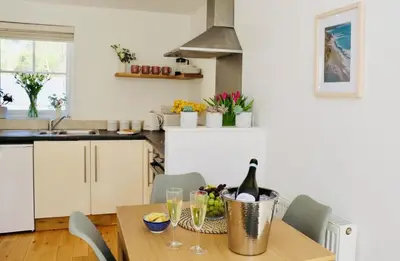 a kitchen with a table with a bottle of wine at Little Peterville in St. Agnes