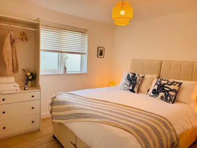 a bedroom with a bed and a dresser and a window at Little Peterville in St. Agnes