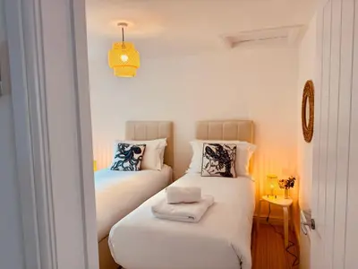 a bedroom with two beds with towels on them at Little Peterville in St. Agnes