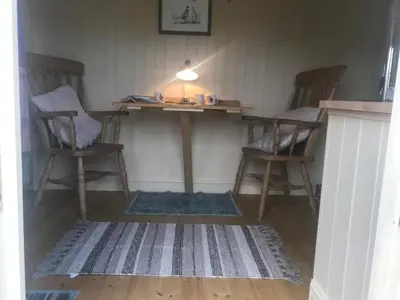 a room with two chairs and a table and a rug at Phoenix Farm Shepherds Hut,Minions, Cornwall in Liskeard