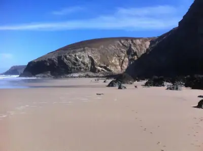 a sandy beach with a mountain in the background at One bed spectacular ocean views, walk to the beach in Truro
