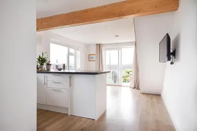 a kitchen with white cabinets and a large window at One bed spectacular ocean views, walk to the beach in Truro