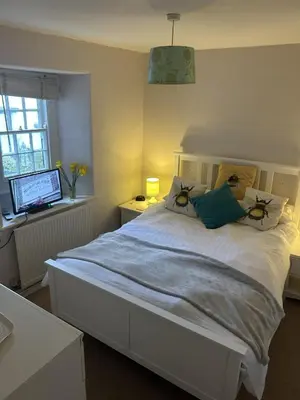 a bedroom with a large white bed with a window at The New Inn in Veryan