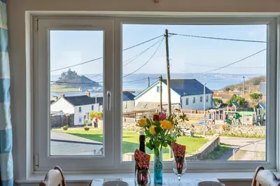 a window with a table with a vase of flowers at Finest Retreats - Chy Merthen East in Marazion