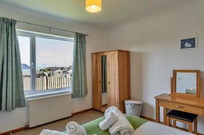 a bedroom with a bed and a window with a balcony at Finest Retreats - Chy Merthen East in Marazion