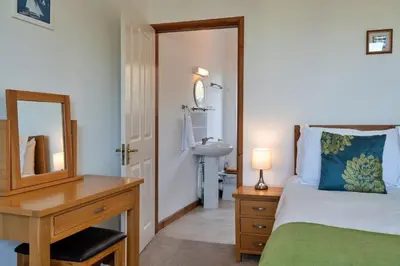 a bedroom with a bed and a desk with a mirror at Finest Retreats - Chy Merthen East in Marazion