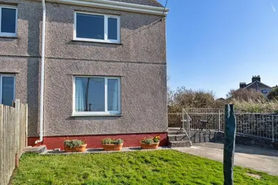a brick house with two windows and potted plants at Finest Retreats - Chy Merthen East in Marazion