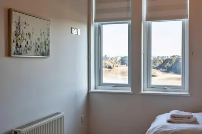 a room with two windows and a bed in it at Finest Retreats - Tidal Shores in Newquay