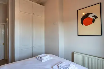 a bedroom with a bed with a picture on the wall at Finest Retreats - Tidal Shores in Newquay