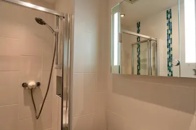 a bathroom with a shower and a mirror at Finest Retreats - Tidal Shores in Newquay