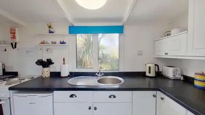 a kitchen with a sink and a window at B12 Branksome, Riviere Towans in Hayle
