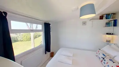a small bedroom with a white bed and a window at B12 Branksome, Riviere Towans in Hayle