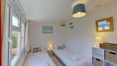 a small room with two beds and a window at B12 Branksome, Riviere Towans in Hayle