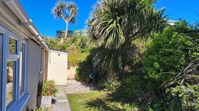 a house with a palm tree next to a house at B12 Branksome, Riviere Towans in Hayle