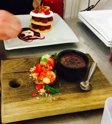 a wooden cutting board with food and a plate of food at The Ship Inn Fowey in Fowey