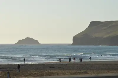 a group of people standing on the beach at St Moritz Hotel Apartments in Polzeath