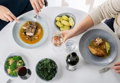 a white table with plates of food on it at St Moritz Hotel Apartments in Polzeath