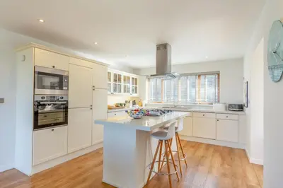 a kitchen with white cabinets and a large island at 5 Bed in Trevone oc-s30762 in Padstow