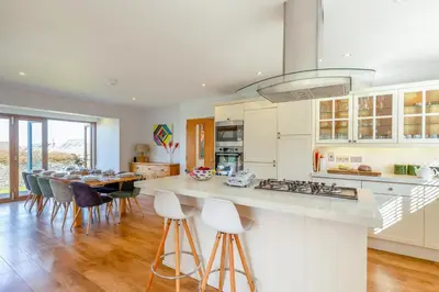 a kitchen with a counter and a table with chairs at 5 Bed in Trevone oc-s30762 in Padstow