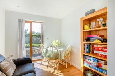 a living room with a table and a book shelf at 5 Bed in Trevone oc-s30762 in Padstow