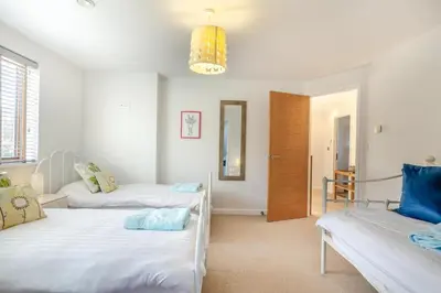a room with two beds and a mirror at 5 Bed in Trevone oc-s30762 in Padstow