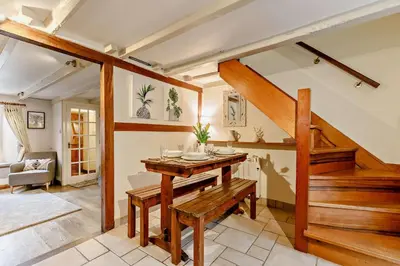 a living room with a wooden table and stairs at 2 Bed in St. Minver oc-p27580 in Saint Minver