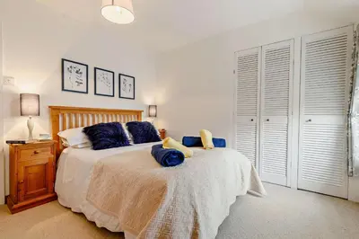 a bedroom with a large bed with blue pillows at 2 Bed in St. Minver oc-p27580 in Saint Minver