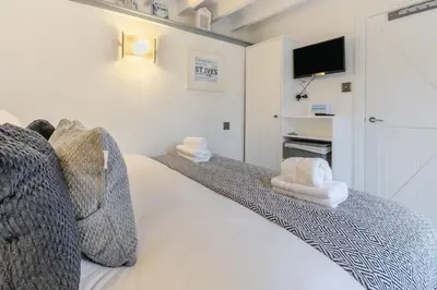 a bedroom with a white bed with towels on it at 2 Bed in St. Ives oc-k30934 in Carbis Bay