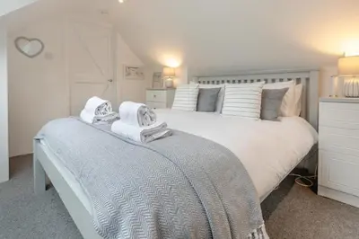 a bedroom with a large white bed with towels on it at 2 Bed in St. Ives oc-k30934 in Carbis Bay