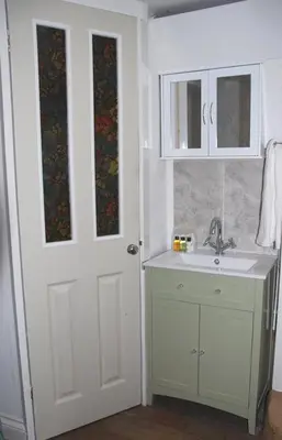 a bathroom with a sink and a white door at Ideally located cottage in Downalong St Ives in St Ives