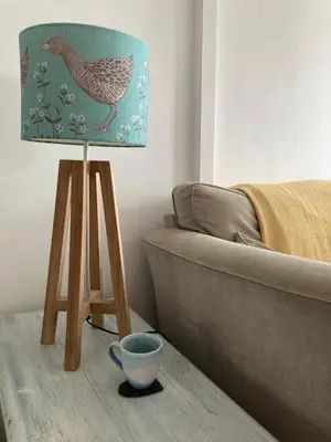 a lamp in a living room next to a couch at Ideally located cottage in Downalong St Ives in St Ives