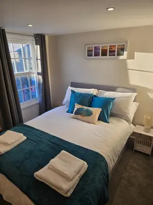 a bedroom with a large bed with towels on it at Ring O Bells in St. Issey