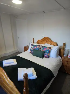 a bedroom with a large bed with towels on it at Ring O Bells in St. Issey