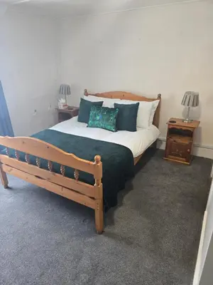 a bedroom with a large wooden bed with pillows at Ring O Bells in St. Issey