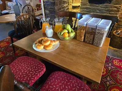 a table with a plate of pastries and drinks on it at Ring O Bells in St. Issey