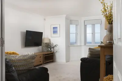 a living room with a tv and two chairs at Bay View, Compass Point, Sea Views, Free Parking and WiFi in Carbis Bay