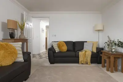 a living room with a black couch and yellow pillows at Bay View, Compass Point, Sea Views, Free Parking and WiFi in Carbis Bay