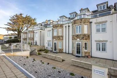 an exterior view of a large white building at Bay View, Compass Point, Sea Views, Free Parking and WiFi in Carbis Bay