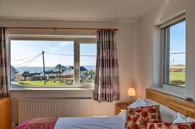 a bedroom with a bed and a large window at Finest Retreats - Chy Merthen House in Marazion