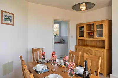 a dining room with a wooden table and chairs at Finest Retreats - Chy Merthen House in Marazion