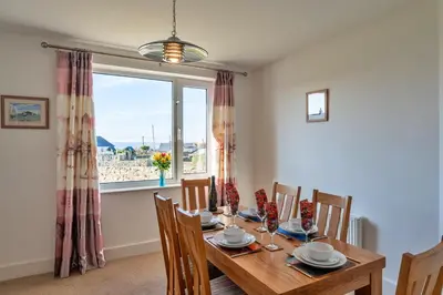 a dining room with a table and chairs and a window at Finest Retreats - Chy Merthen House in Marazion