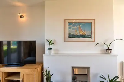 a living room with a fireplace and a tv at Finest Retreats - Chy Merthen House in Marazion