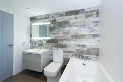 a bathroom with a toilet and a sink and a mirror at Salubrious Cottage, St Ives in St Ives