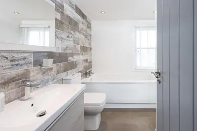 a bathroom with a sink and a toilet and a tub at Salubrious Cottage, St Ives in St Ives
