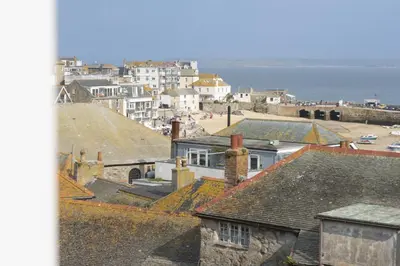 a view of roofs of houses and the ocean at Salubrious Cottage, St Ives in St Ives