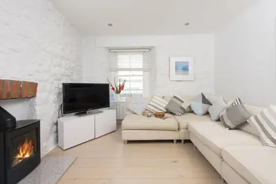 a living room with a couch and a fireplace at Serendipity Cottage, St Ives in St Ives