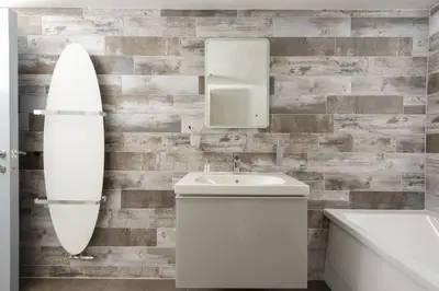 a bathroom with a sink and a surfboard on the wall at Serendipity Cottage, St Ives in St Ives