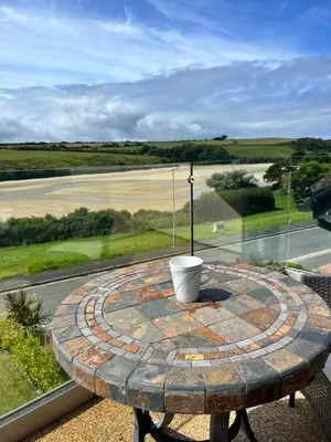 a patio table with a bucket on top of it at Whispering Waters in Newquay