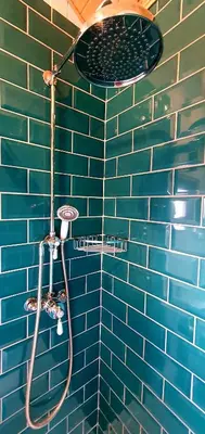 a blue tiled bathroom with a shower with at Cornwall Luxury Hot Tub Huts in Camelford